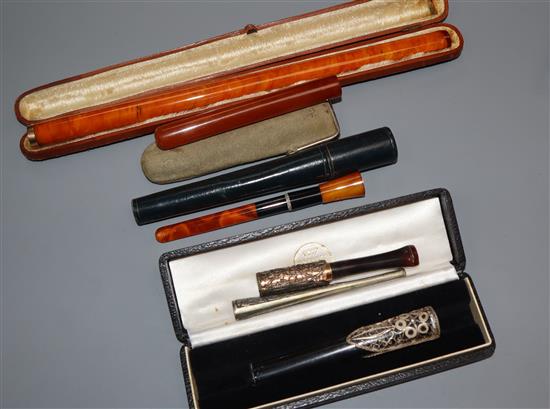 Three amber cigarette holders and three others longest 24cm